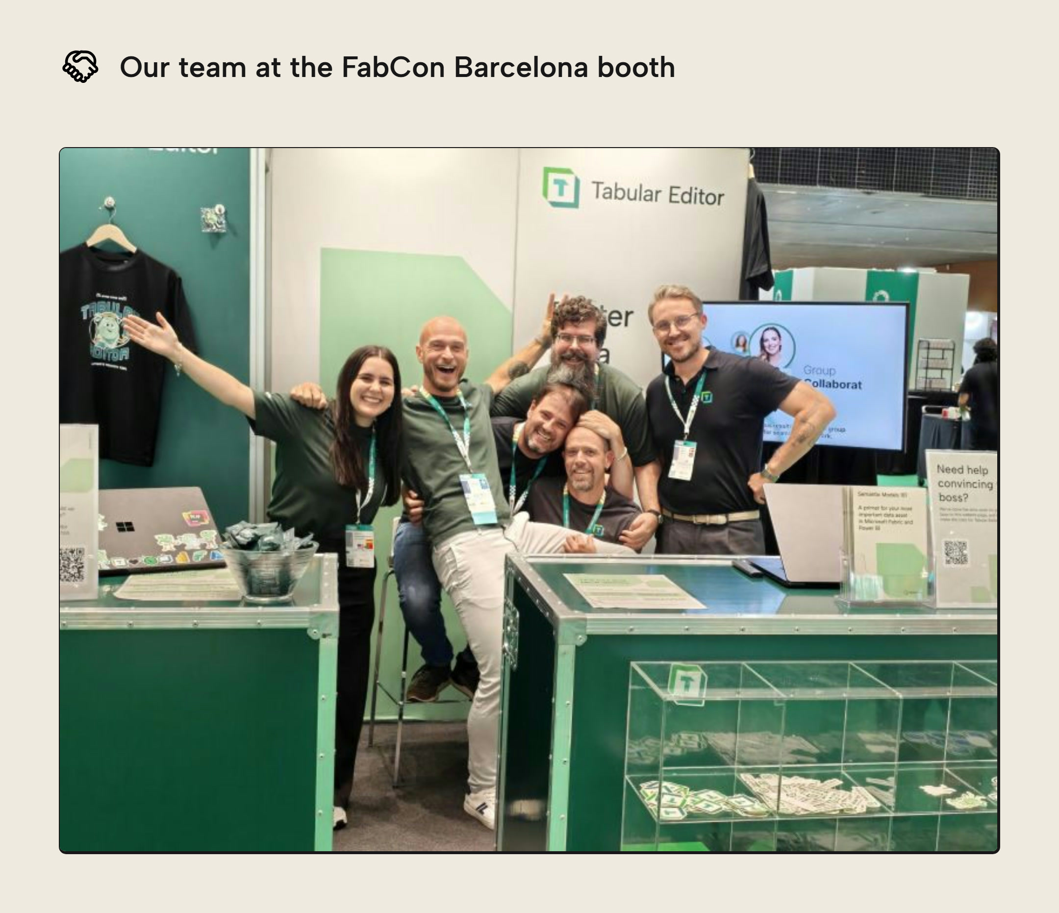 The Tabular Editor team at the FabCon Barcelona booth, posing behind the counter with a display case of stickers in front